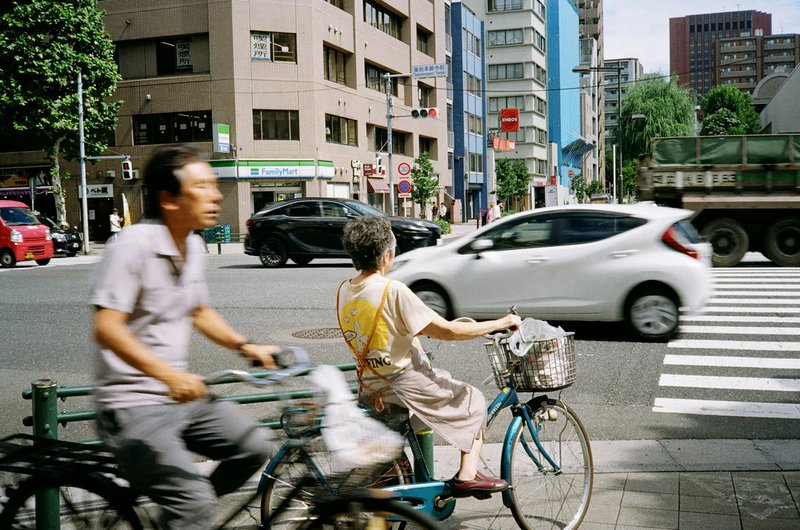 A couple of people riding bikes down a street